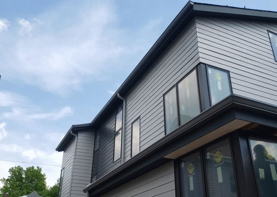 Modern two-story house exterior with roof gutters along the eaves